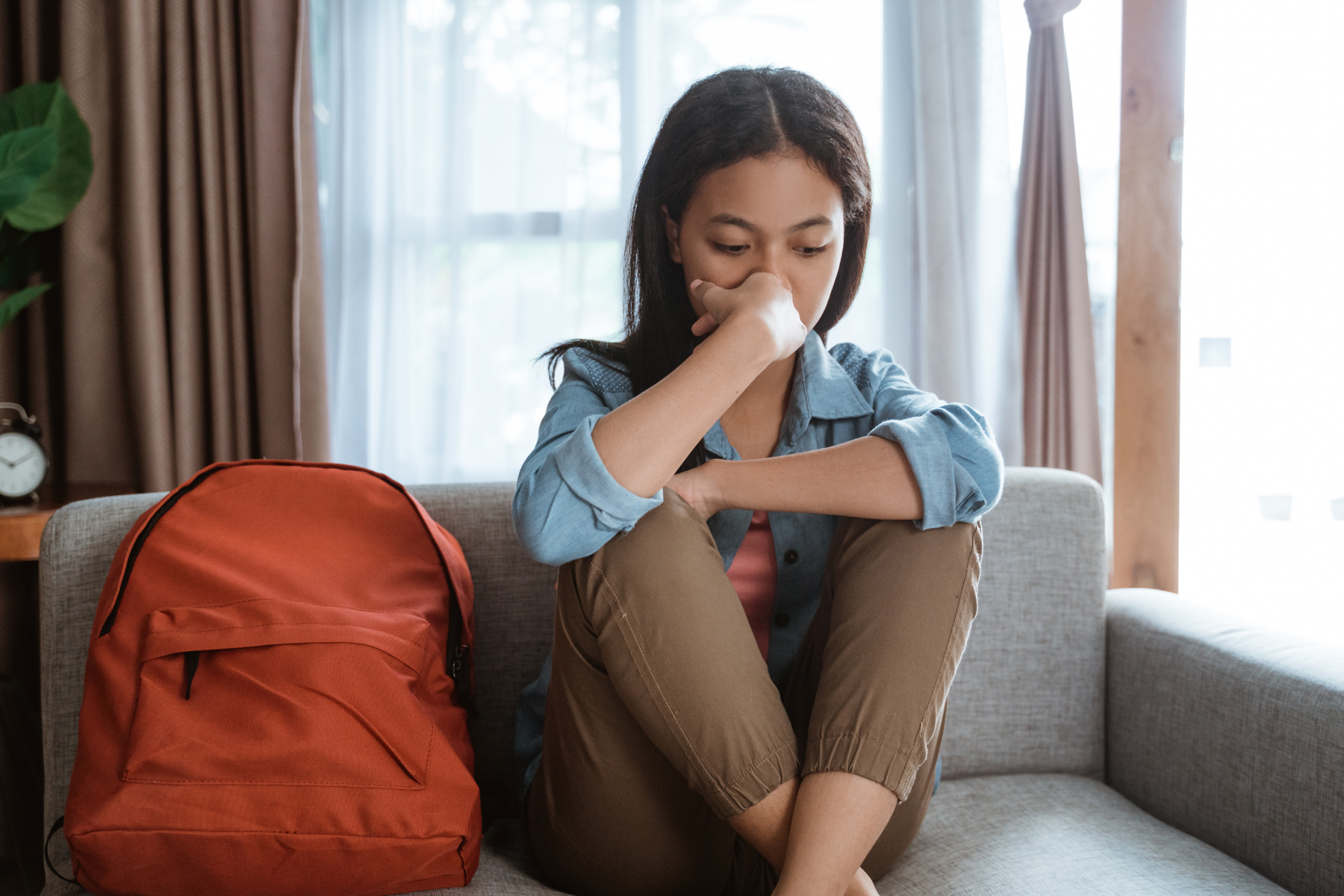 depressed teen sitting on sofa