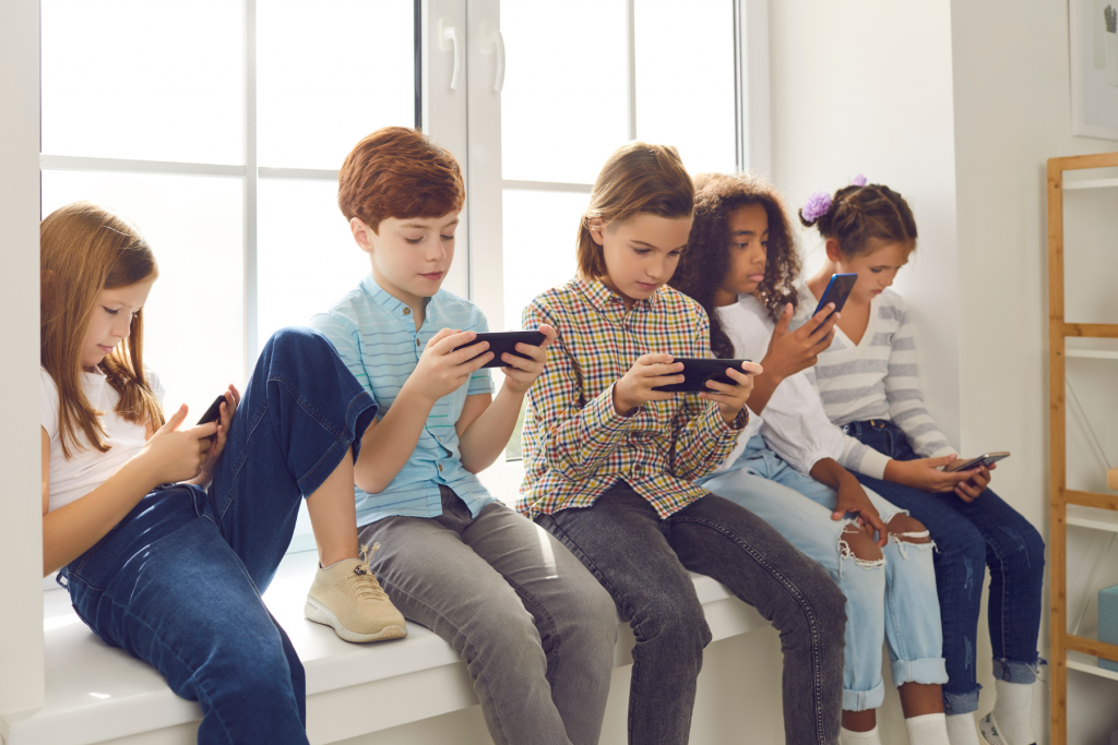 row of kids on smartphones because parent caved and gave them